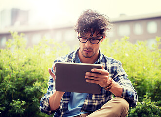 Image showing man in glasses with tablet pc on city steet