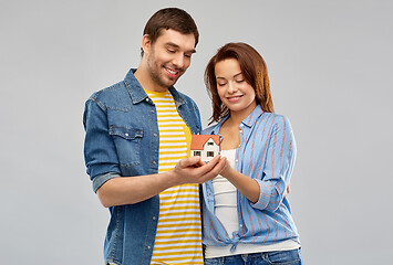 Image showing smiling couple holding house model