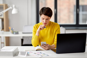 Image showing smiling ui designer using smartphone at office