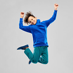 Image showing portrait of smiling boy in blue hoodie jumping