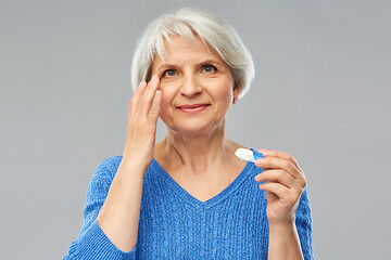 Image showing senior woman applying contact lenses