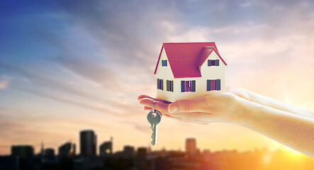 Image showing close up of hands holding house model and keys