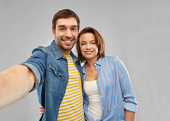 Image showing happy couple taking selfie over grey background