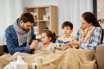 Image showing family with medicine treating ill children at home