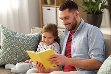 Image showing happy father and daughter reading book at home