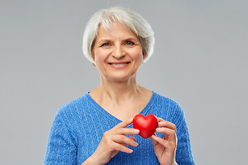 Image showing smiling senior woman with red heart