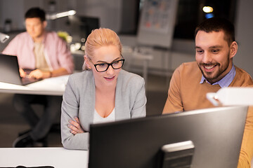 Image showing business team with computer working late at office