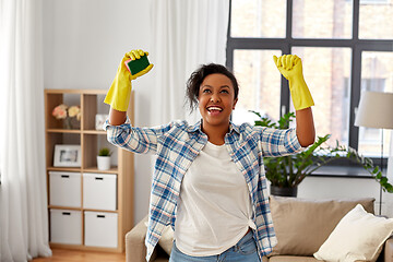 Image showing happy african woman with sponge cleaning at home