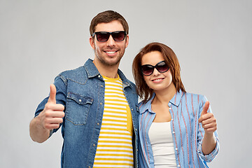 Image showing happy couple in sunglasses showing thumbs up