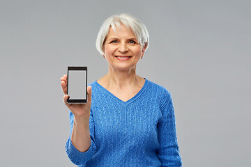 Image showing smiling senior woman showing smartphone