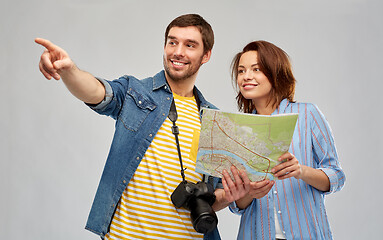 Image showing happy couple of tourists with map and camera