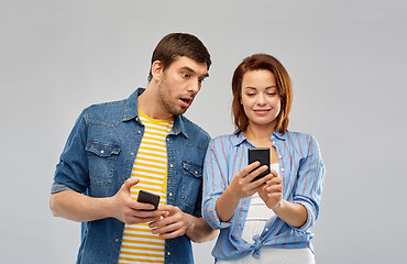 Image showing couple using smartphones over grey background