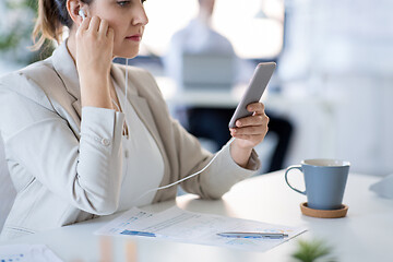 Image showing businesswoman with earphones and smartphone