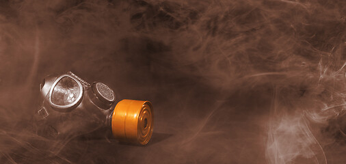 Image showing Vintage gasmask isolated on black - Smoke in the room - Orange f