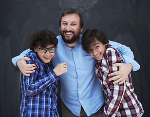 Image showing happy father hugging sons