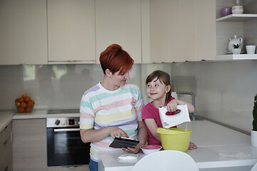 Image showing Mother and daughter playing and preparing dough in the kitchen.