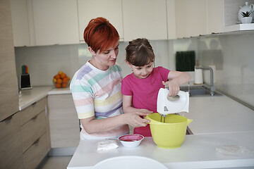 Image showing Mother and daughter playing and preparing dough in the kitchen.