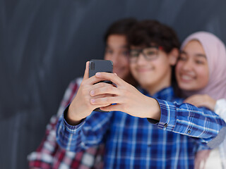 Image showing group of arab teens taking selfie photo on smart phone