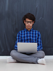 Image showing Arab teenager using laptop to work on homework  at home