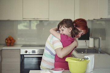 Image showing Mother and daughter playing and preparing dough in the kitchen.