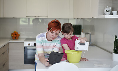 Image showing Mother and daughter playing and preparing dough in the kitchen.