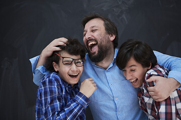 Image showing happy father hugging sons