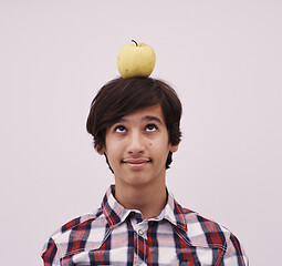 Image showing portrait of a young  teen boy with an apple on his head