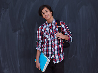 Image showing arab teenager  with school backpack and books against black chal