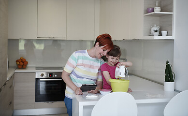 Image showing Mother and daughter playing and preparing dough in the kitchen.