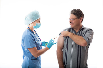 Image showing A man receives the influenza vaccine by a treatment nurse