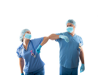 Image showing nurses in scrubs elbow bump instead of shaking hands during COVI