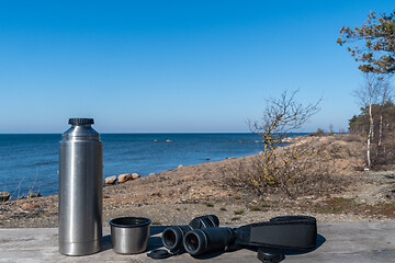 Image showing Thermos and binoculars on a table