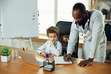 Image showing Little caucasian boy as a doctor consulting for patient, working in cabinet, close up