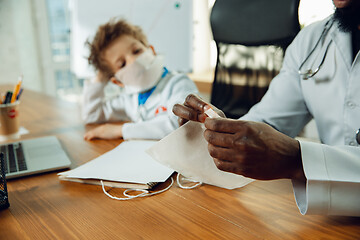 Image showing Little caucasian boy as a doctor consulting for patient, working in cabinet, close up