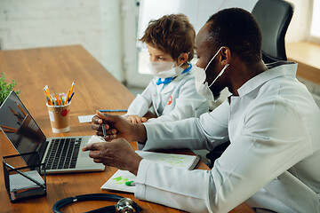 Image showing Little caucasian boy as a doctor consulting for patient, working in cabinet, close up