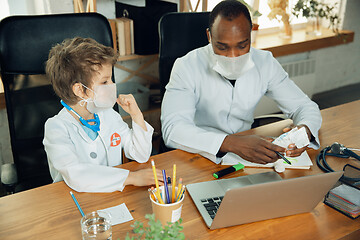 Image showing Little caucasian boy as a doctor consulting for patient, working in cabinet, close up