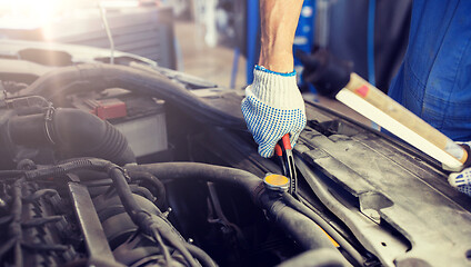 Image showing mechanic man with pliers repairing car at workshop