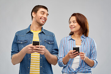 Image showing happy couple with smartphones talking