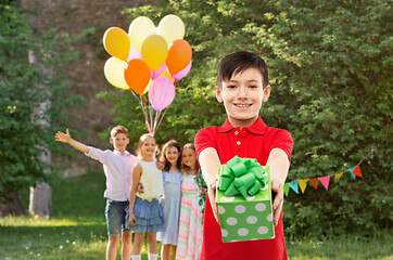 Image showing boy with gift box at birthday party in summer park