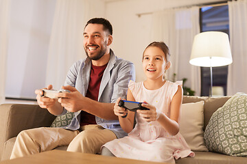 Image showing father and daughter playing video game at home