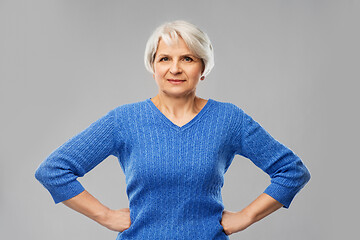 Image showing senior woman in blue sweater hands on hips