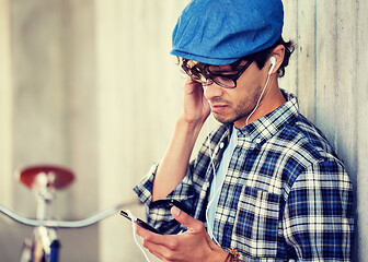 Image showing hipster man with earphones, smartphone and bike