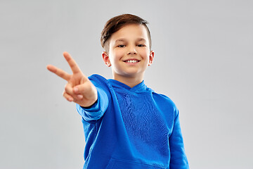 Image showing smiling boy in blue hoodie showing peace gesture