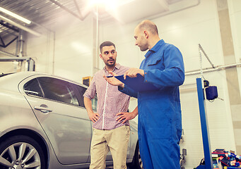 Image showing auto mechanic with clipboard and man at car shop