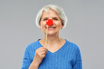 Image showing smiling senior woman with red clown nose