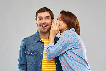 Image showing happy couple whispering over grey background