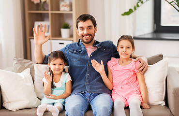 Image showing happy father with daughters waving hands at home