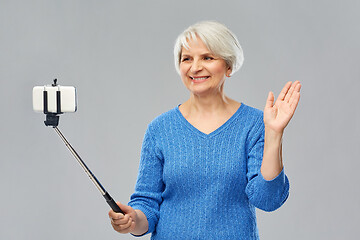 Image showing smiling senior woman taking selfie by smartphone