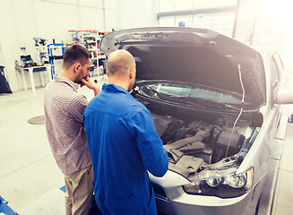 Image showing auto mechanic and man or car owner at workshop