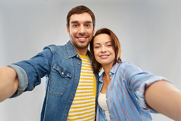 Image showing happy couple taking selfie over grey background